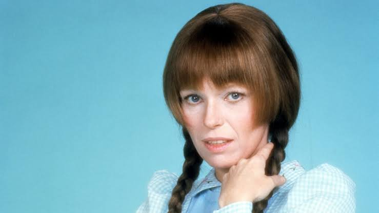 Louise Lasser as Mary Hartman wearing pigtails and a patterned dress